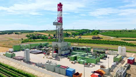 oil field - onshore drilling rig with agriculture field - aerial drone shot