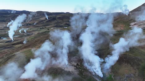 steam rising from hot springs in geothermal valley in hveragerdi, south iceland - drone shot