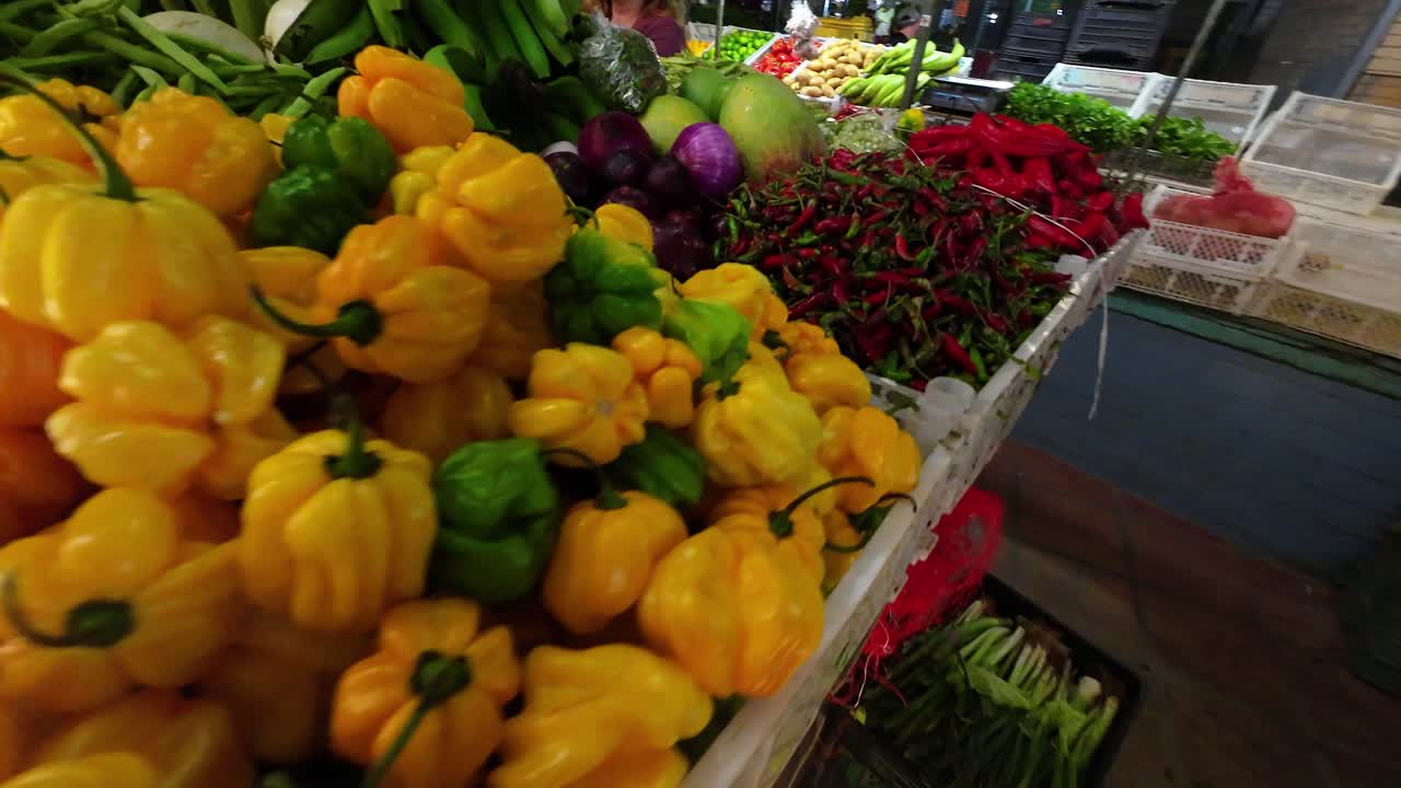 Side pan over colorful hot pepper varieties on display at Quinta Crespo public market in Caracas.
