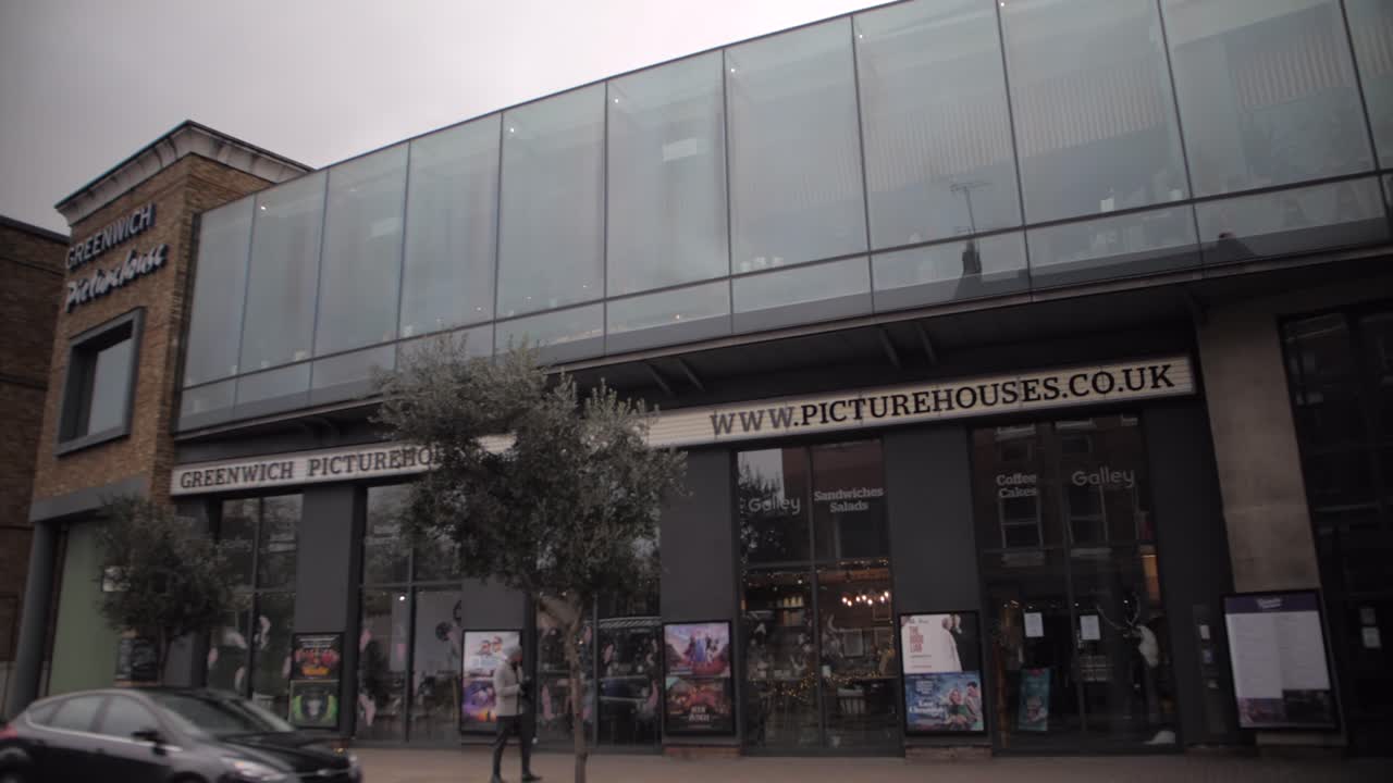 A red bus passing by in front of Greenwich Picturehouse.