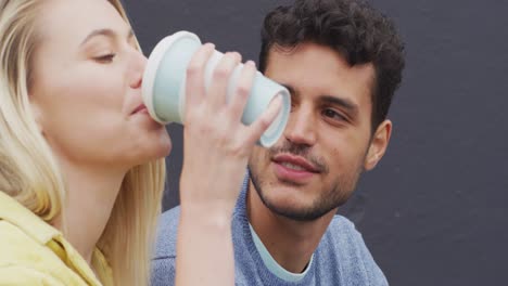 Seitenansicht-Eines-Kaukasischen-Paares,-Das-Auf-Einer-Treppe-Sitzend-Einen-Kaffee-Zum-Mitnehmen-Trinkt