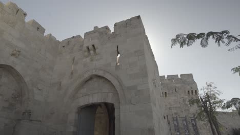 Entrance-to-ancient-building-in-the-Middle-East,-with-sun-peaking-from-behind-it