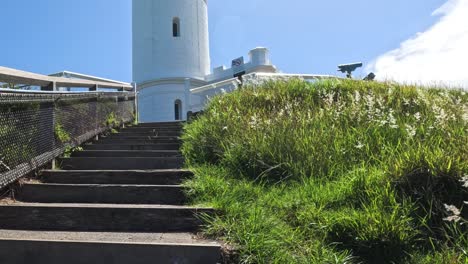 sube progresivamente las escaleras a un faro blanco
