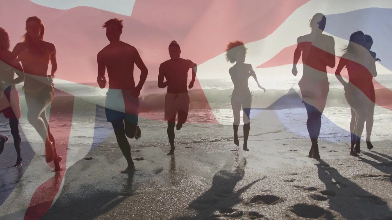 フィットネス目的でビーチの波打ち際から走り出す8人のランナー。カメラがクローズアップし、イギリス国旗のオーバーレイが重なる。
