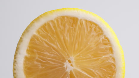 Slow-Motion-Macro-Shot-of-Flowing-Water-from-Lemon-Slice-on-white-Background