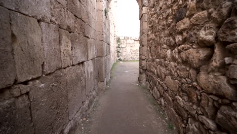 Caminando-Por-Un-Camino-Estrecho-Con-Paredes-De-Piedra-Antiguas-De-Los-Lados