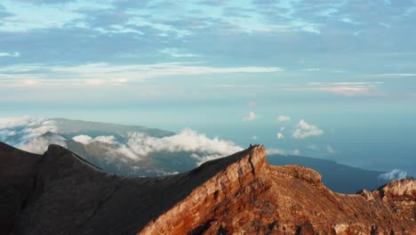 orange mountain cliff peak ridge at sunrise, drone flying over. valley in the background. 4k footage.