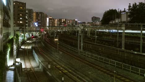 time-lapse video of trains moving on multiple railway tracks at night in tokyo