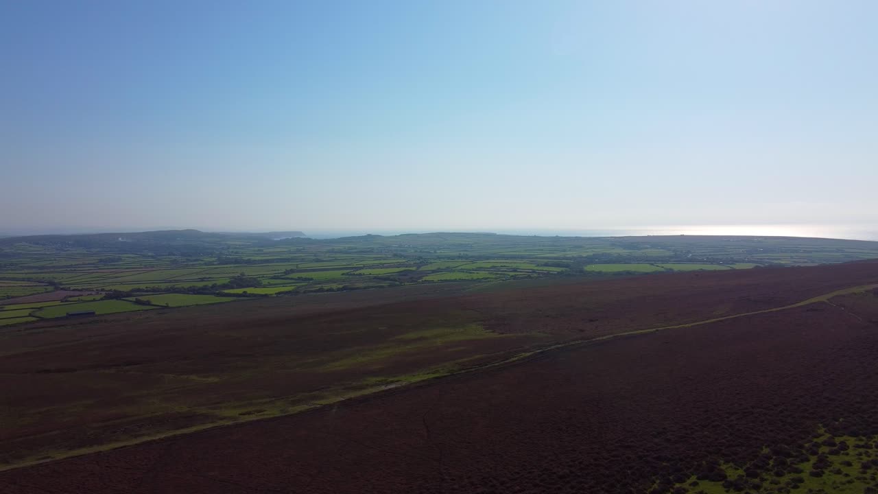 Wide Landscape View of Welsh Countryside Fields and Moorland in Gower Peninsula with Sun Reflecting on Ocean Sea in Background Distance 4K