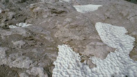 overhead aerial of natural pool on a mountain with melting snow during summer