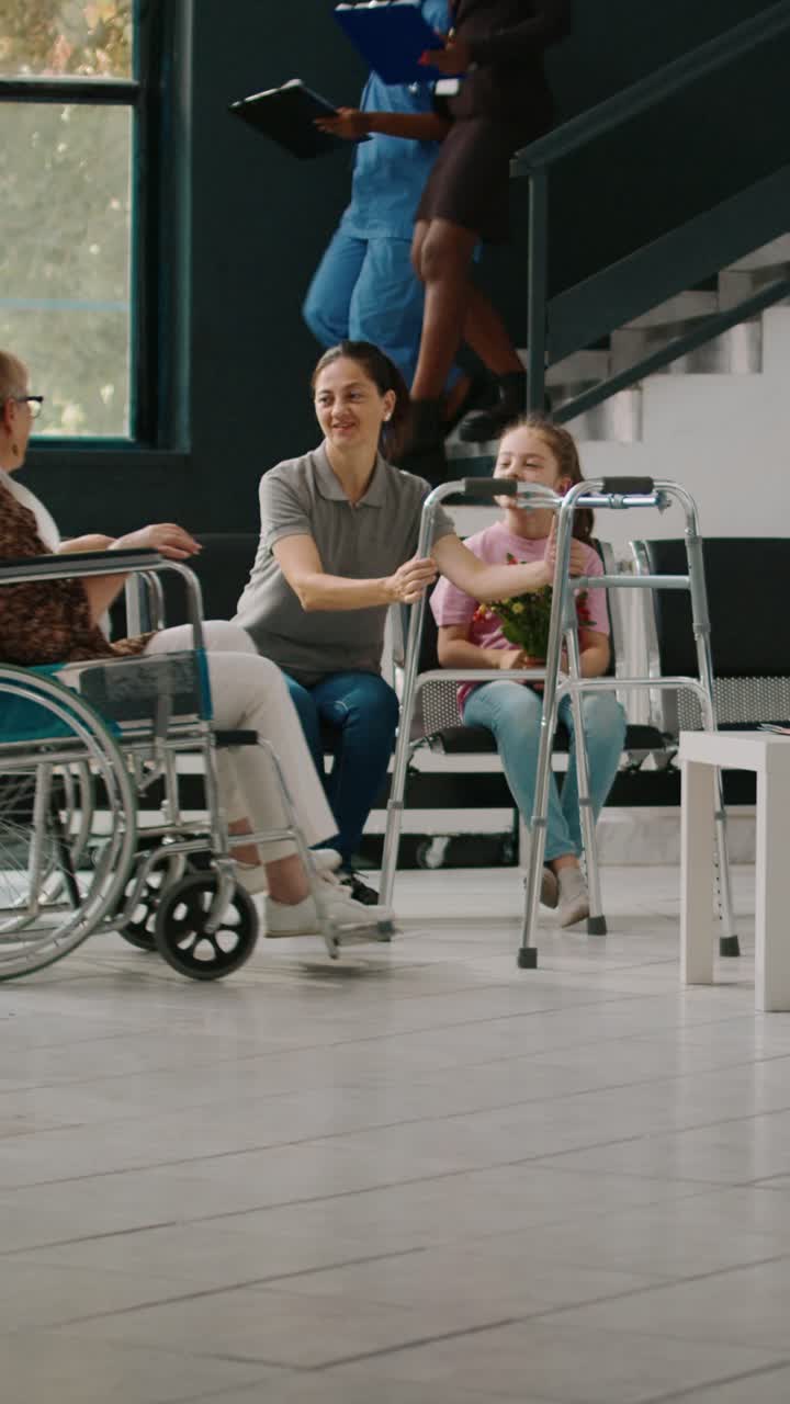 Anziana in sedia a rotelle riceve la visita dei familiari