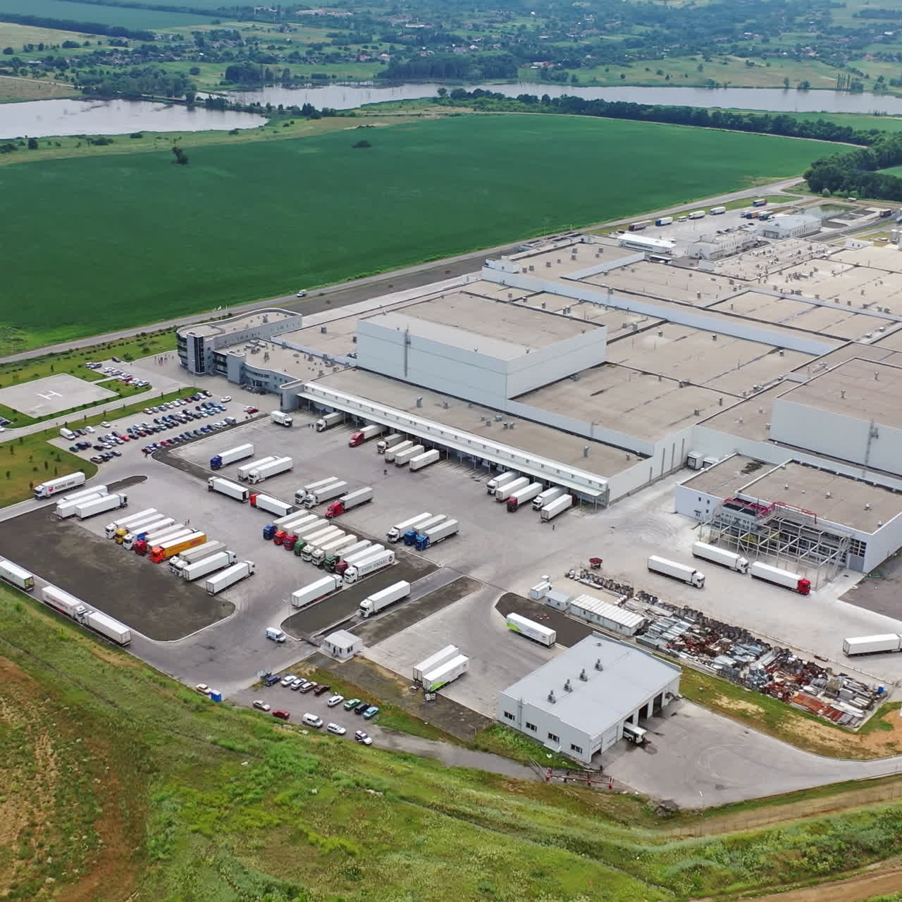 Modern industrial area with large trucks outdoors. Aerial view of manufacturing complex in a sunny day. Industrial territory.