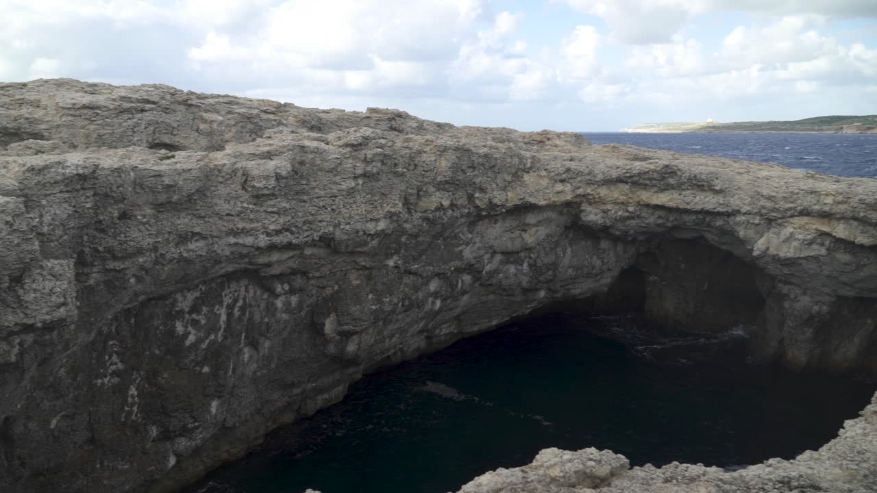 vista panorámica de la cueva de la laguna de coral en malta llena de agua profunda en un día ventoso