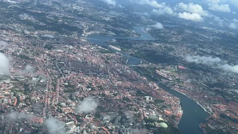 Elevated-spinning-aerial-view-of-Porto-city,-Portugal,-shot-from-an-airplane-cockpit