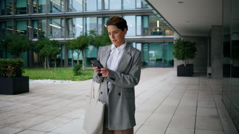 office worker walking downtown street. pensive executive stop to reply message