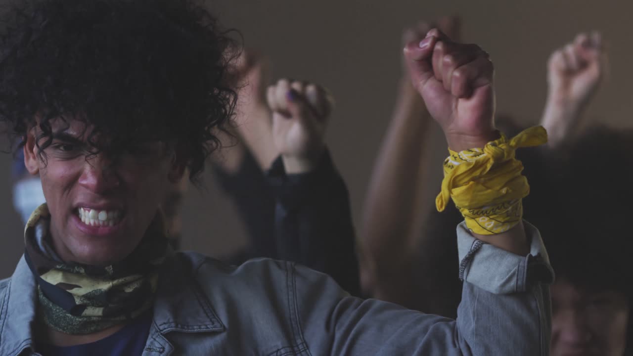 grupo diverso de personas con máscaras faciales sosteniendo carteles de protesta gritando levantando puños