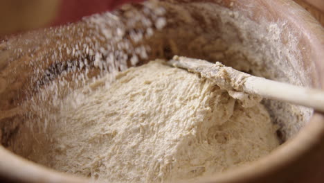 baking - sprinkling flour over batter, sourdough bread, slow motion zoom in