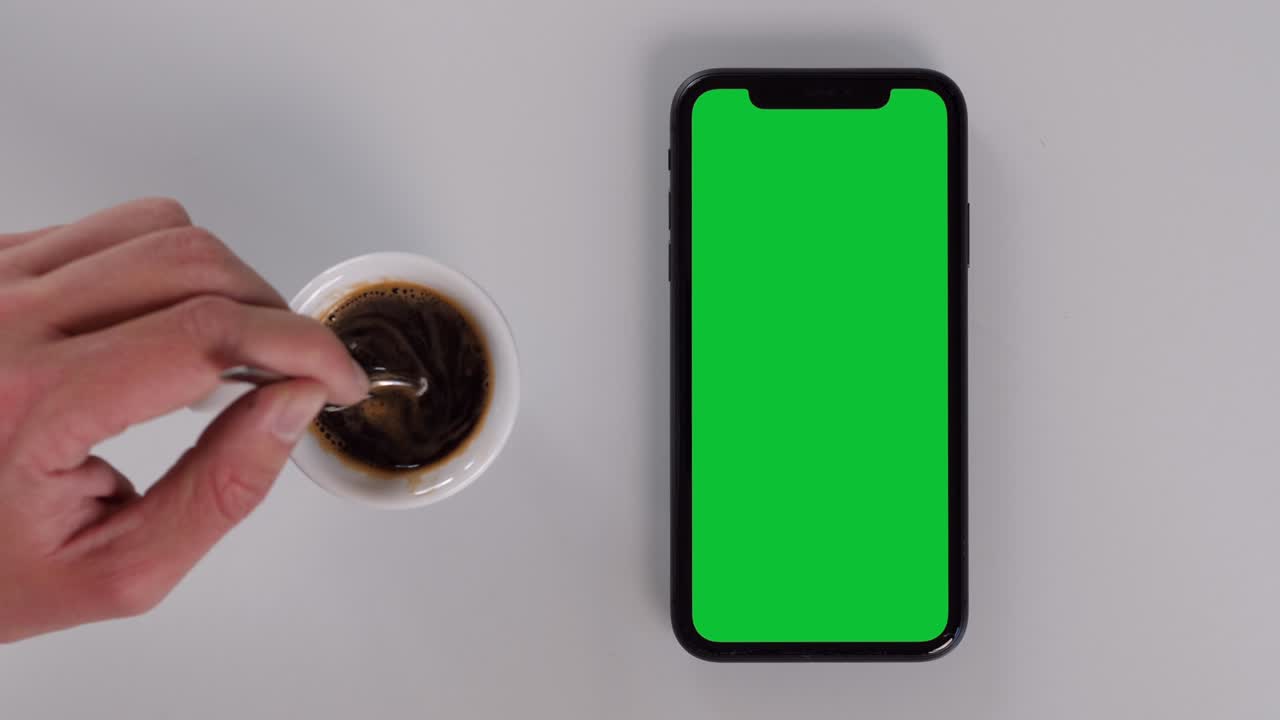 tocando y sosteniendo un teléfono inteligente de pantalla verde