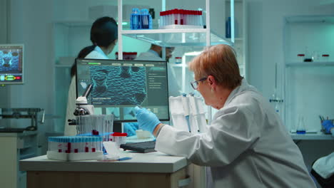 medical research scientist typing genetic codes on pc