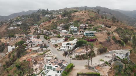 wide reverse aerial pullback shot affected properties at las flores canyon after the wildfire in malibu, california. 4k