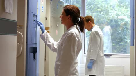 científicos que usan un refrigerador grande en el laboratorio