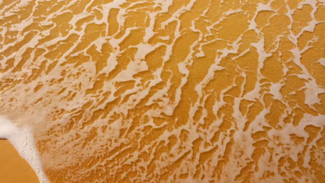 waves washing over sand on a beach