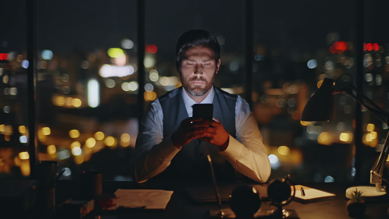 Manager texting cellphone overtime at dark cityscape closeup. Focused man using