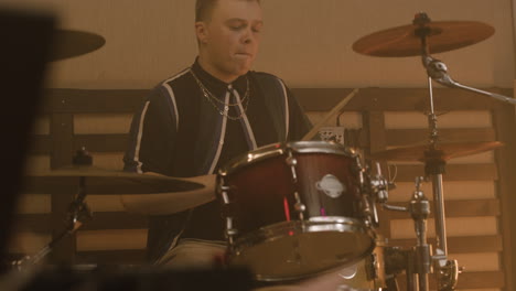 male musician playing drums during a band rehearsal in recording studio 2