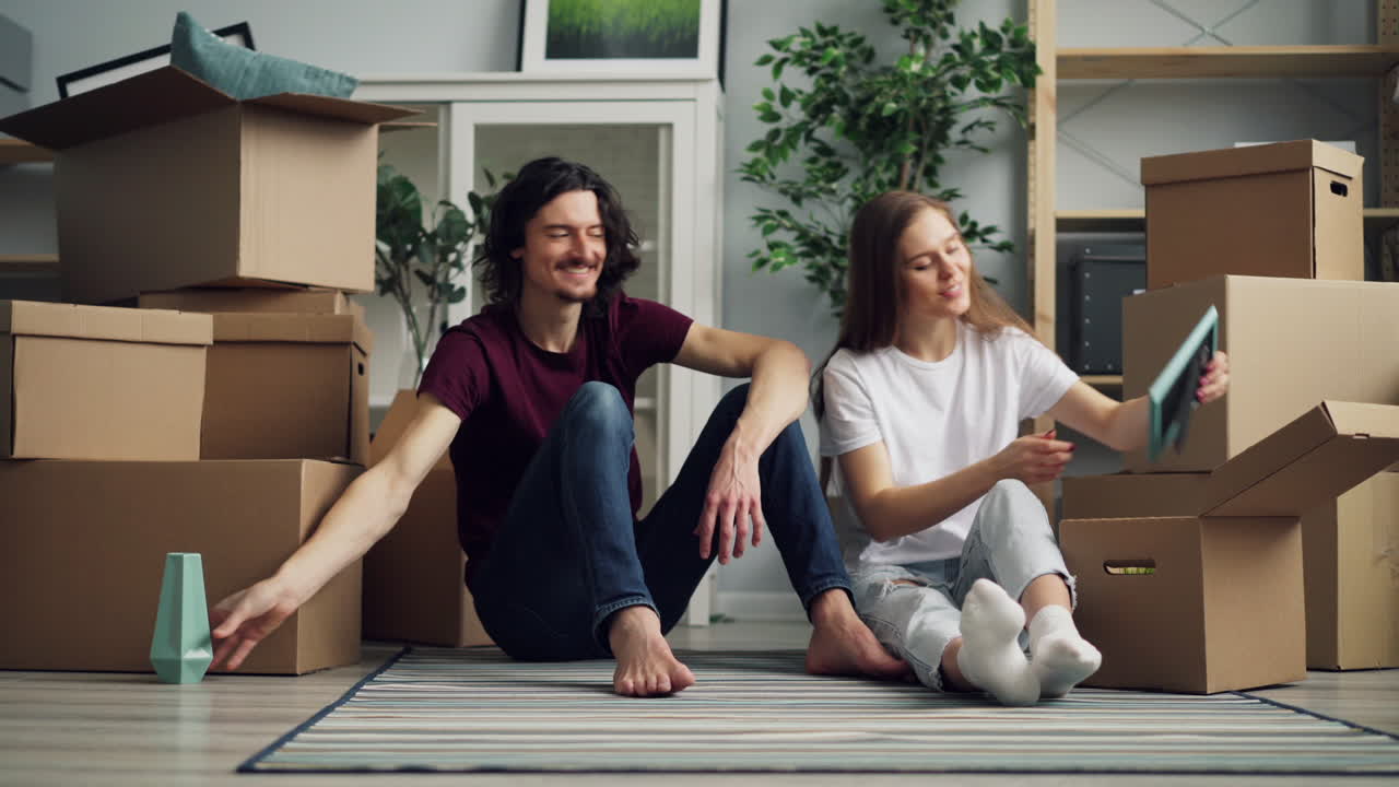 una pareja desempaquetando cajas en su nuevo hogar.