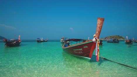 un hermoso cinemagraph 4k uhd de una playa tropical junto al mar en koh life, tailandia con un famoso bote de cola larga