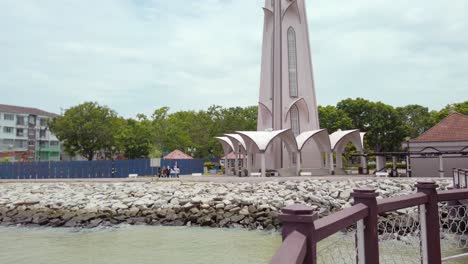 Cinematic-low-to-high-shot-of-the-minaret-of-Masjid-Selat-Melaka-in-Melaka,-Malaysia,-during-a-cloudy-day-in-daylight