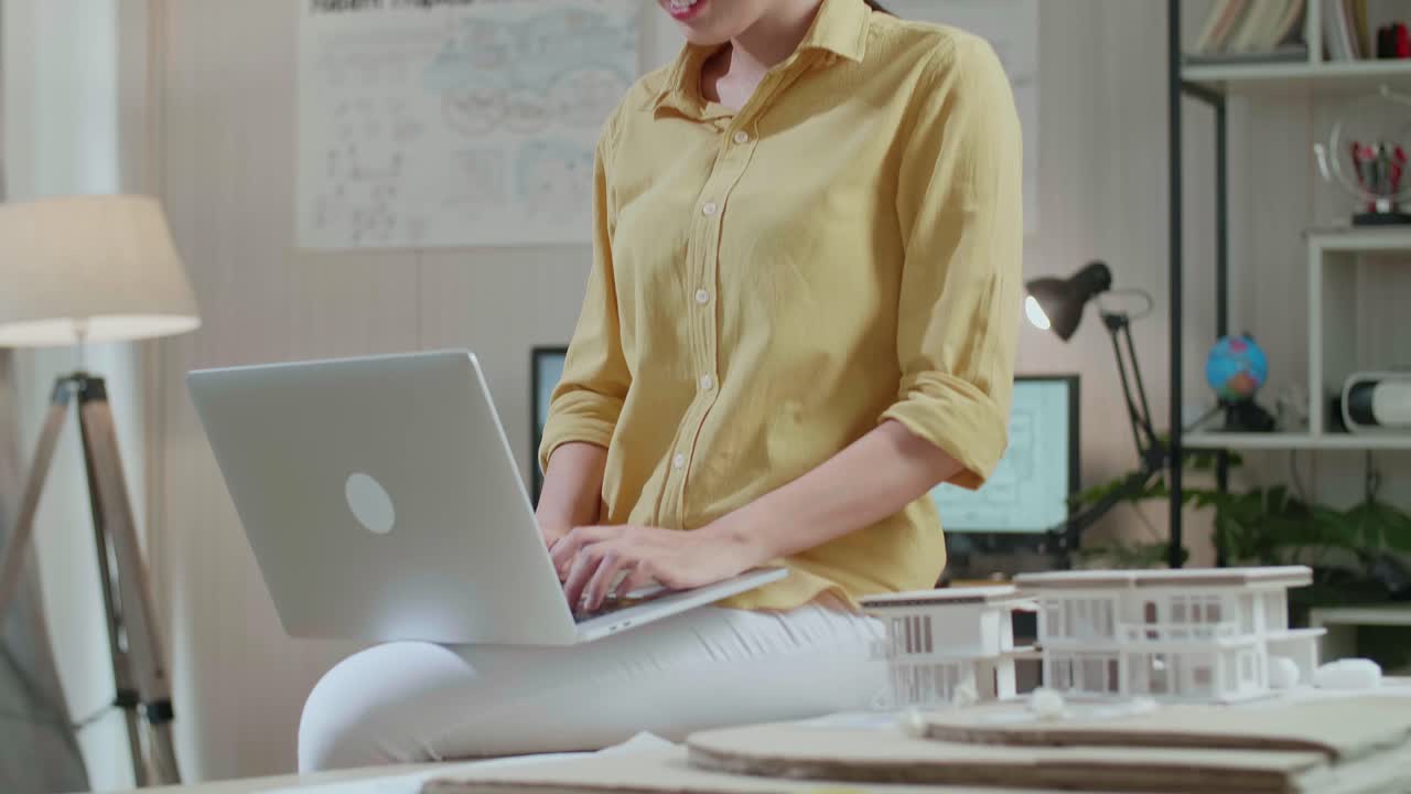 Asian Woman Engineer Sitting On The Table And Using A Laptop To Work At The Office