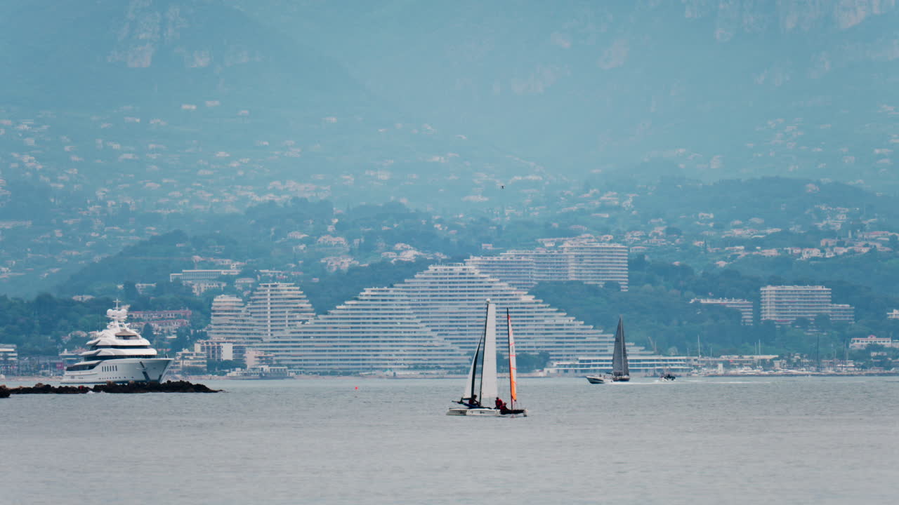 Distant view of multiple boats moving near the Marina Baie des Anges in Villeneuve-Loubet, France