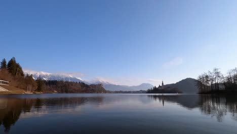 Zeitraffervideo-Aus-Slowenien,-Bleder-See-Mit-Den-Schneebedeckten-Alpen-Im-Hintergrund