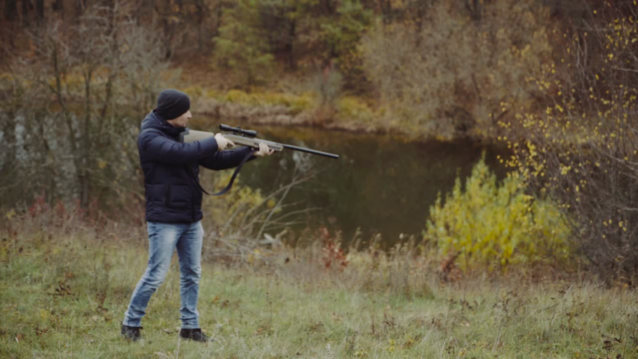 Hunter aiming for wildlife. Close up of hunter aiming down his rifle in autumn season