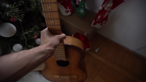 gifts and presents under the xmas tree. christmas tree with christmas decorations and christmas lights and guitar on background