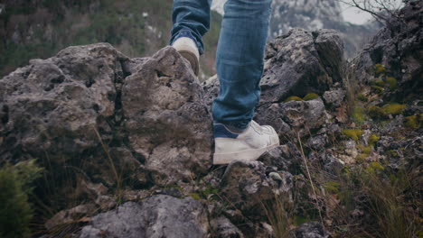 Legs-stand-confident-on-rocky-edge,-hiker-exploring-mountains