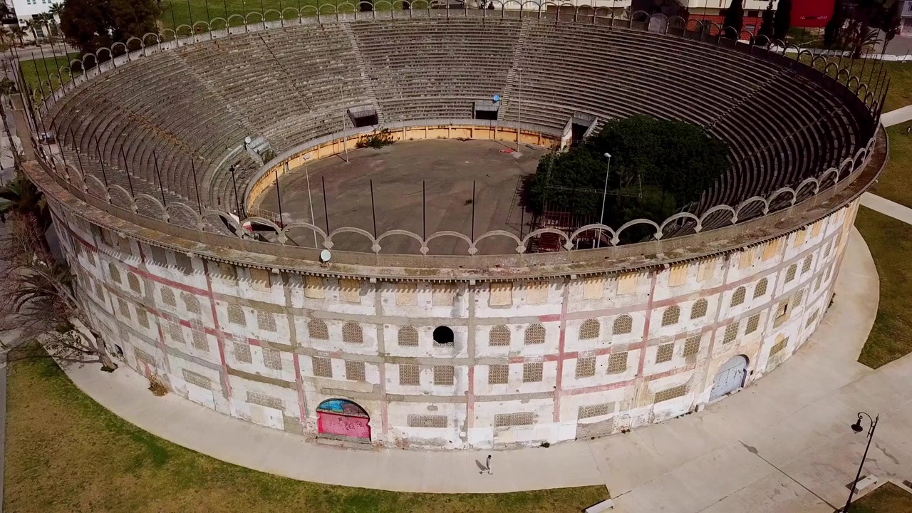 Drone aerial of the historic Spanish bullring in Tangier, Morocco, an iconic circular arena reflecting colonial-era architecture and cultural heritage.