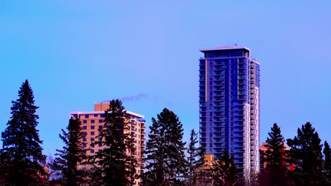 Hilltop-and-the-Saskatchewan-condominium-behind-tall-pine-trees-time-lapse-next-to-the-Hendrix-Rental-Apartment-from-the-lower-Victoria-Park-view-time-lapse-winter-weather-twilight-sunset-navy-blue