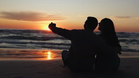 selfie, puesta de sol y silueta de la pareja