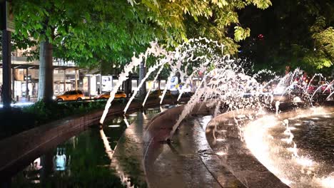 columbus circle, ny, fuentes nocturnas iluminadas añaden ambiente a la zona área de lujo y compras en la ciudad de nueva york