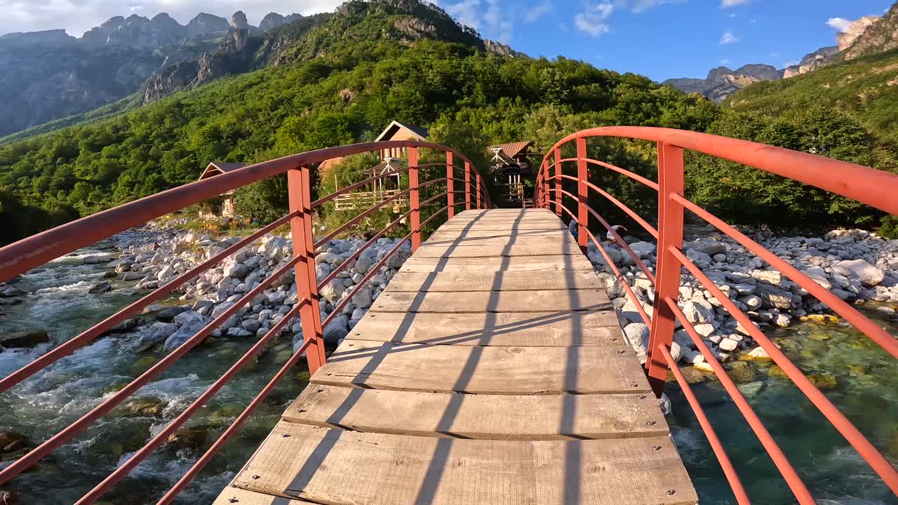 Paesaggio montano panoramico con fiume e ponte di legno