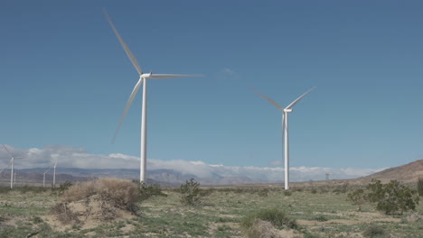 large wind turbines spin and generate renewable electricity in a strong desert wind