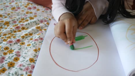 una niña dibuja un cuadro con lápices de colores