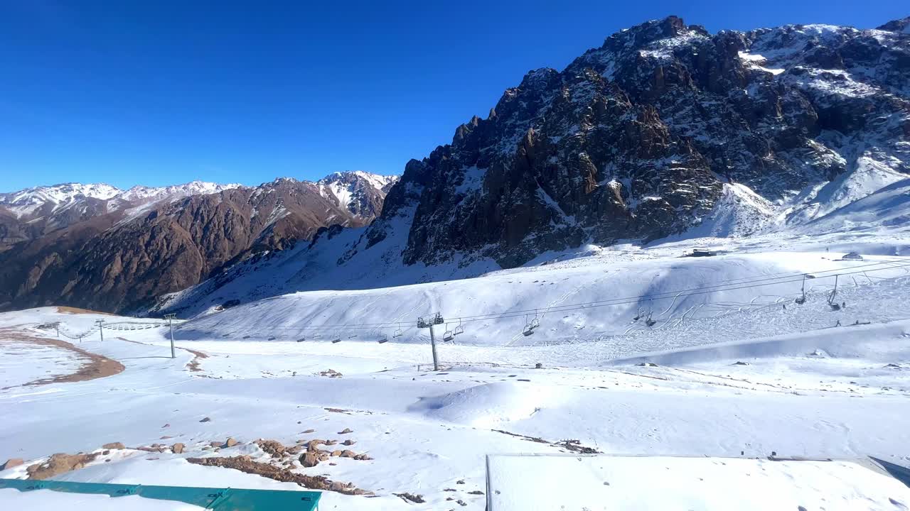 금속 로프로 케이블웨이를 지원하여 빛 파란 하늘의 배경에서 후니쿨러 의자 장비를 움직입니다.