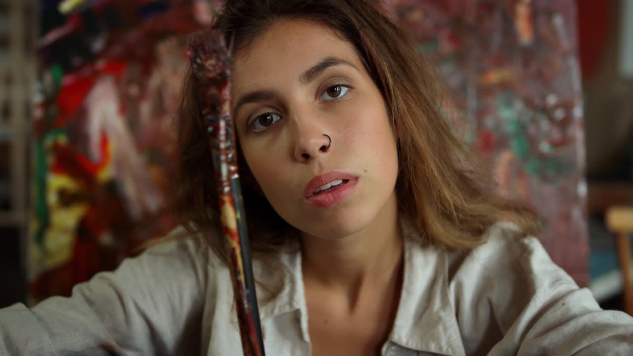 mujer creativa tomando selfies en el estudio de arte. pintor mirando la cámara en el lugar de trabajo.