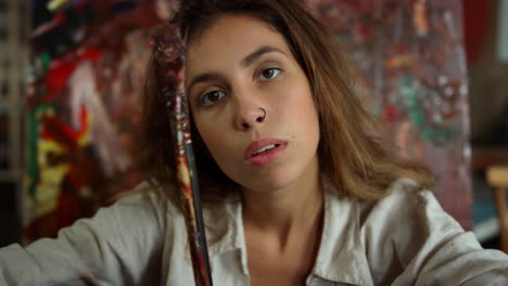 mujer creativa tomando selfies en el estudio de arte. pintor mirando la cámara en el lugar de trabajo.