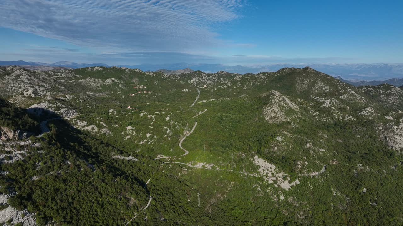Green mountains in montenegro under a bright blue sky, aerial view