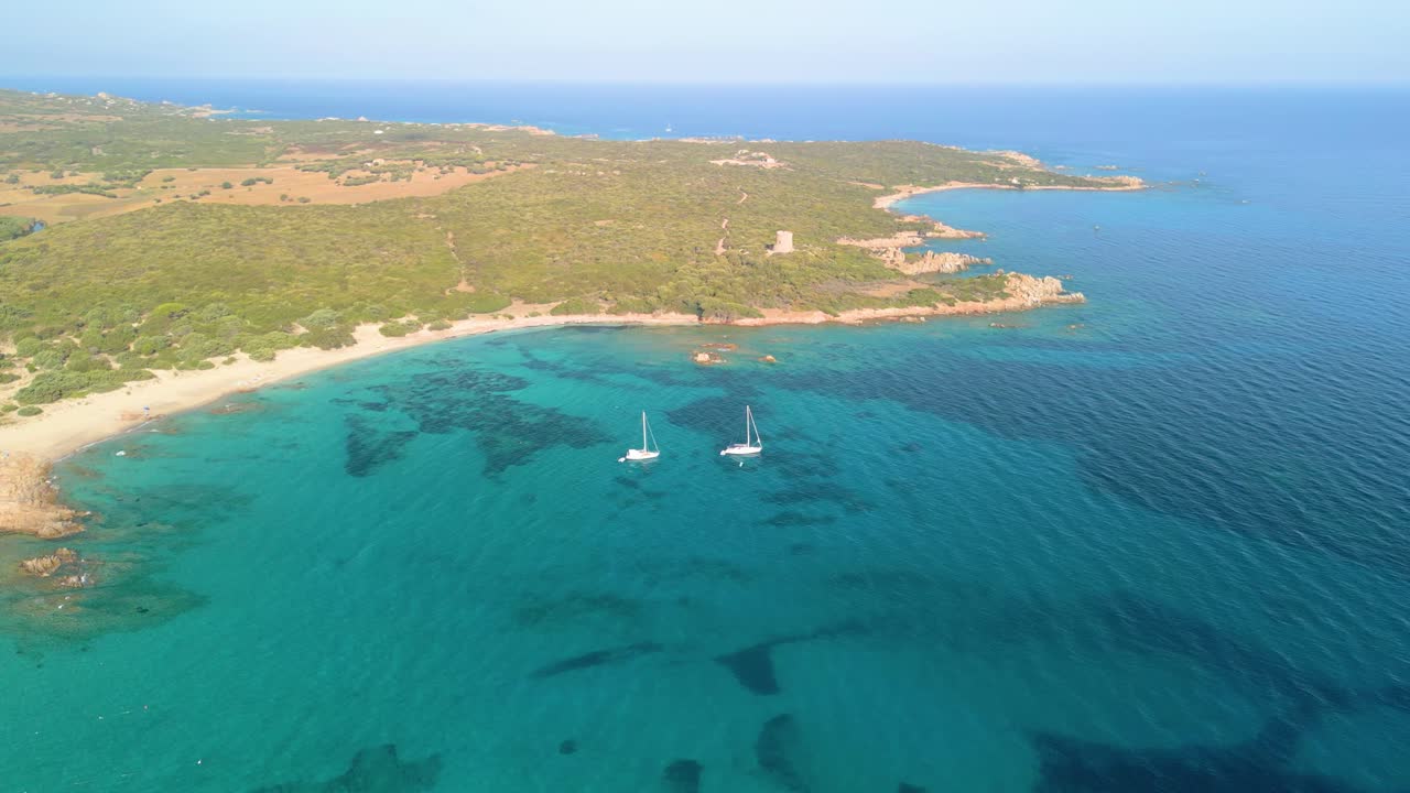 Imagem aérea da Sardenha, praia paradisíaca com dois veleiros ancorados no Mediterrâneo azul, mar transparente
