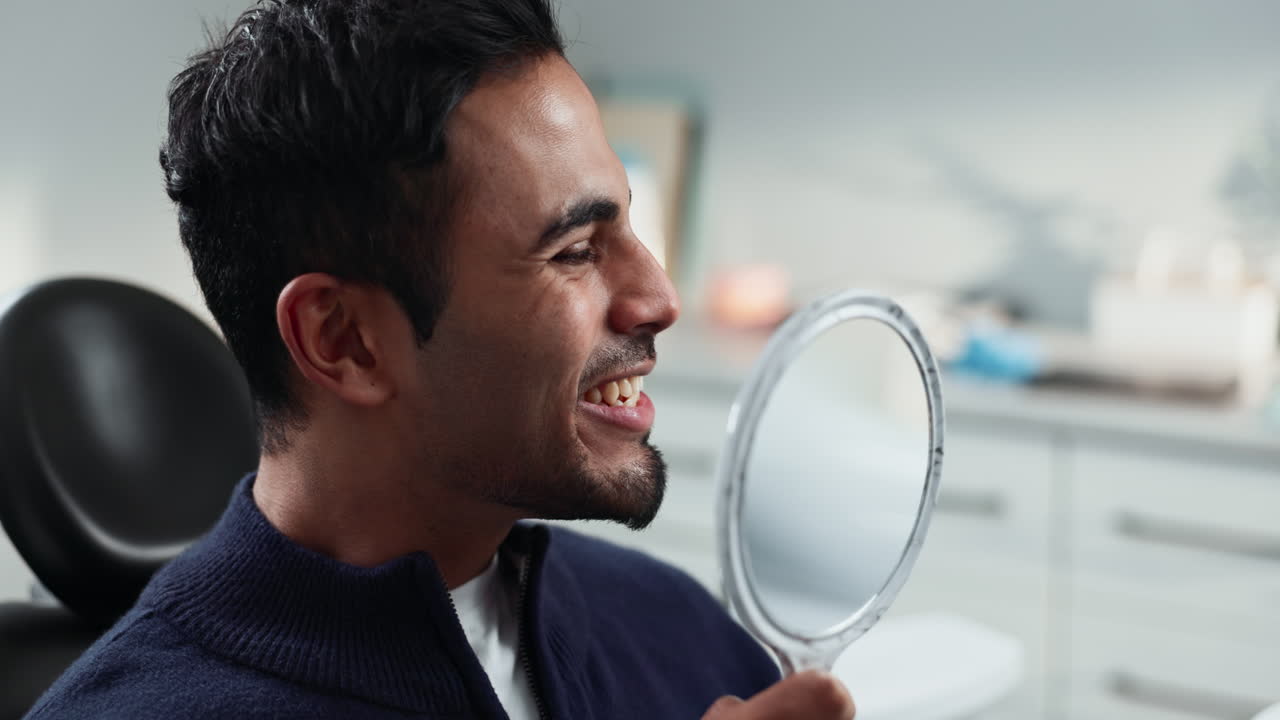 Man smiling at the mirror in a dental office